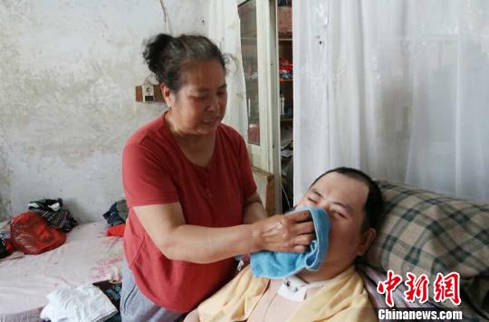 每次喂完食物后，梁青蘭都要仔細(xì)地幫兒子清理干凈?！∩忻鱾b 攝