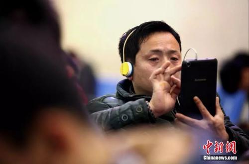 資料圖：候車(chē)室內(nèi)，玩手機(jī)的“低頭族”隨處可見(jiàn)。刷微博、聊微信、玩游戲、看電影，高科技將大多旅客變?yōu)槭謾C(jī)“低頭族”。<a target='_blank' ><p  align=