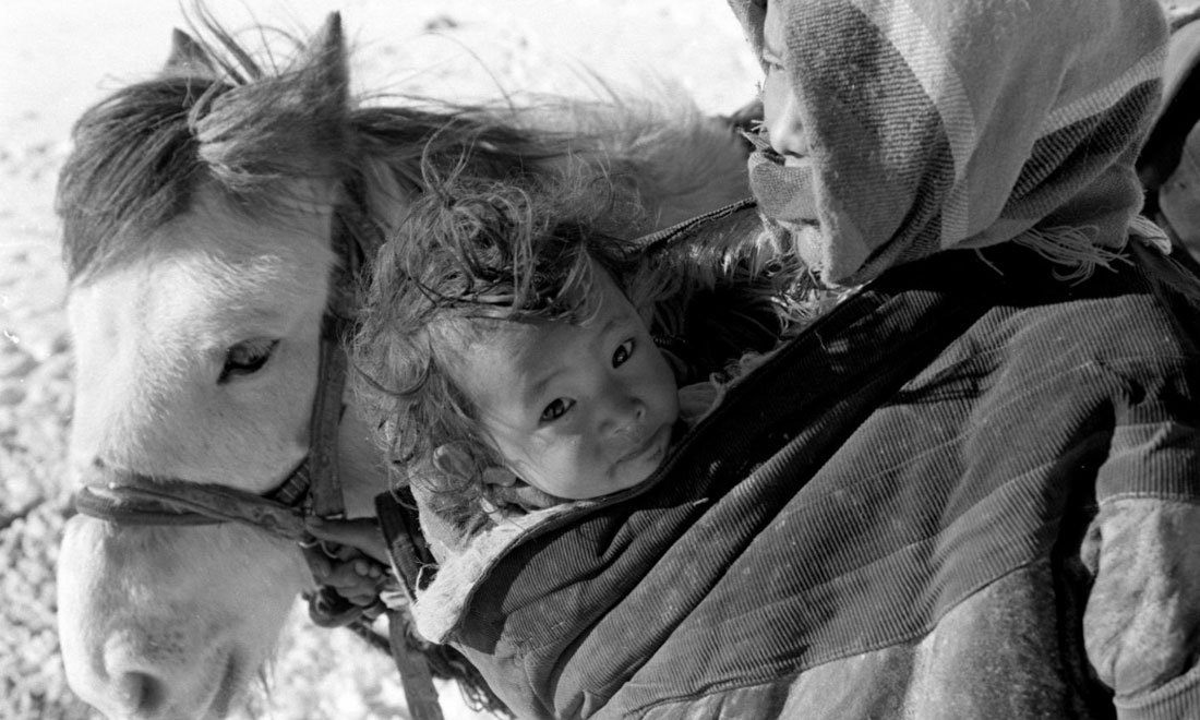 1990年3月，西藏當(dāng)雄縣納木湖鄉(xiāng)三村女牧民斯卓不畏嚴(yán)寒，懷抱幼子，準(zhǔn)備到遠(yuǎn)處放牧。新華社記者覺(jué)果攝