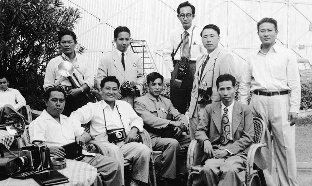 新華社記者錢嗣杰（站立者右二）在采訪會議開幕式后和外國記者在會場外休息。